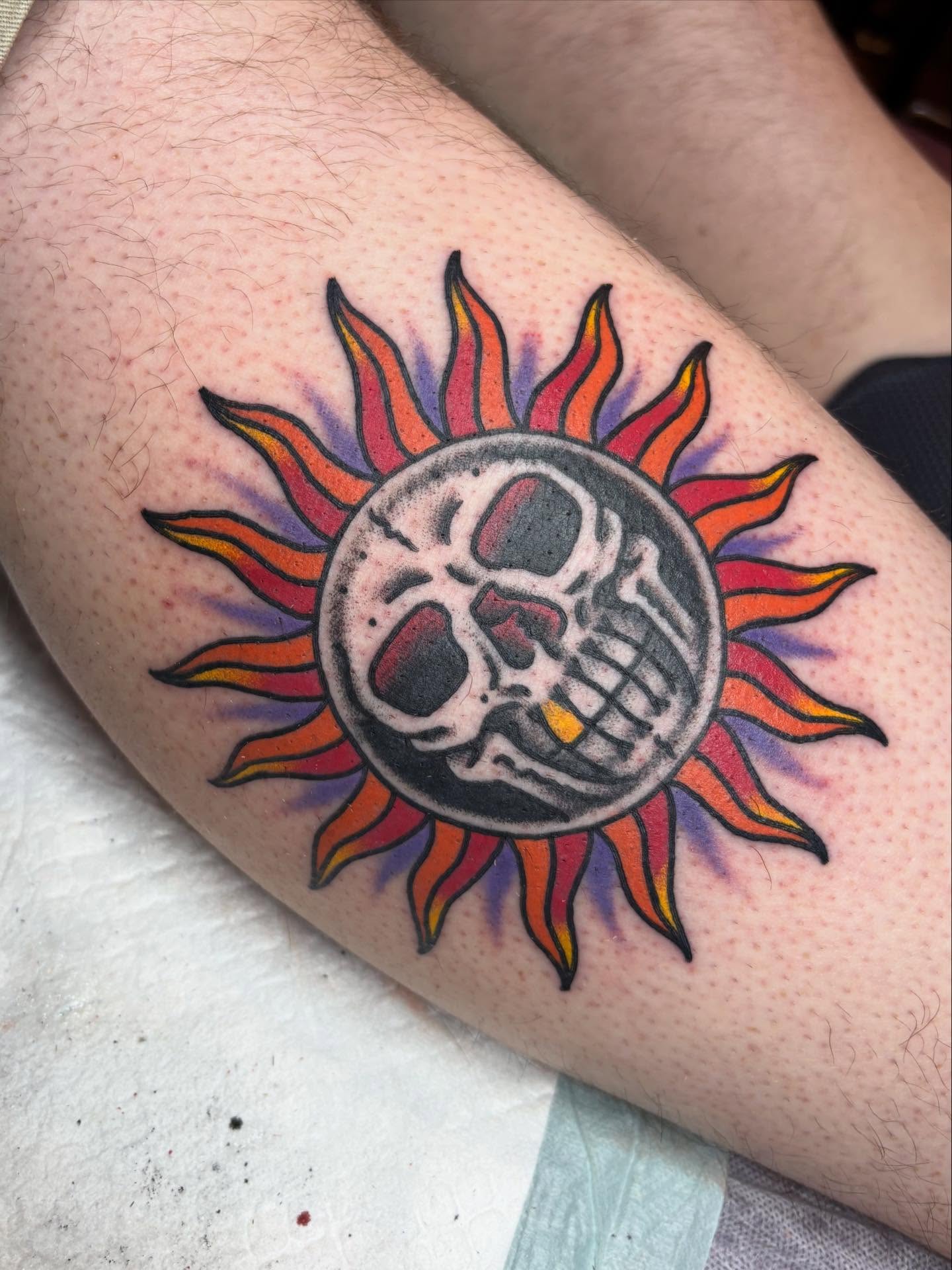 Skull and sun American traditional tattoo on the forearm by Josh Albers