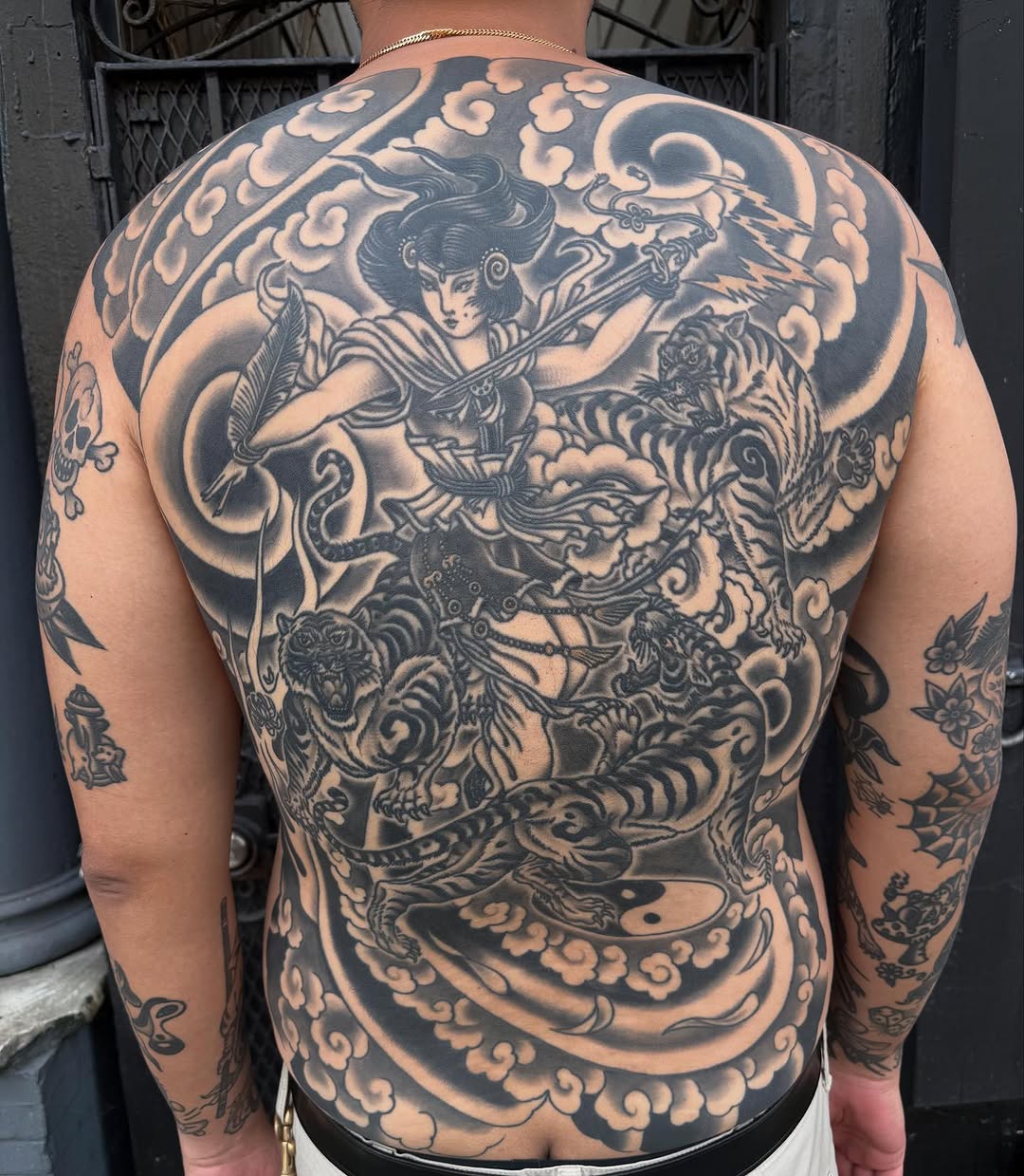 Woman fighting tigers with clouds Japanese tattoo on the back by Ross K. Jones Tattoos, San Francisco, California