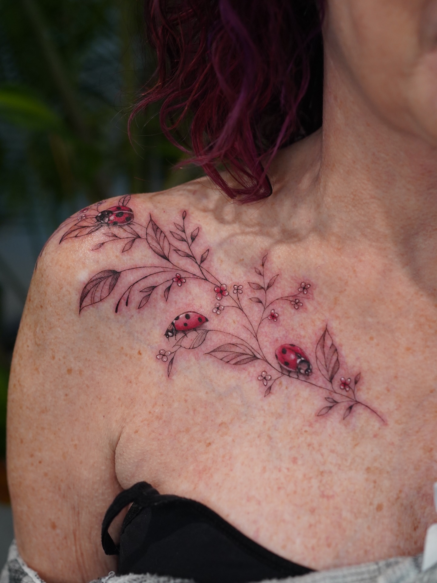 Ladybugs and flowers fine line tattoo on the shoulder by Jess Dominguez