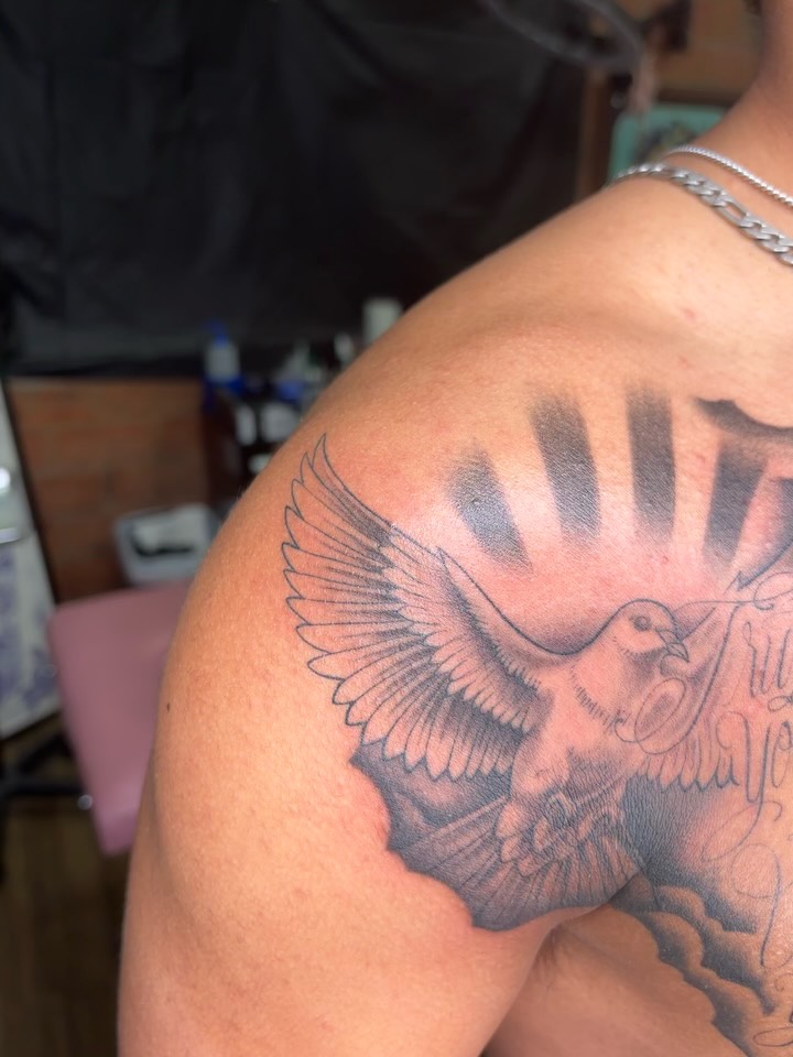 Dove with banner black and grey tattoo on the shoulder by Jay