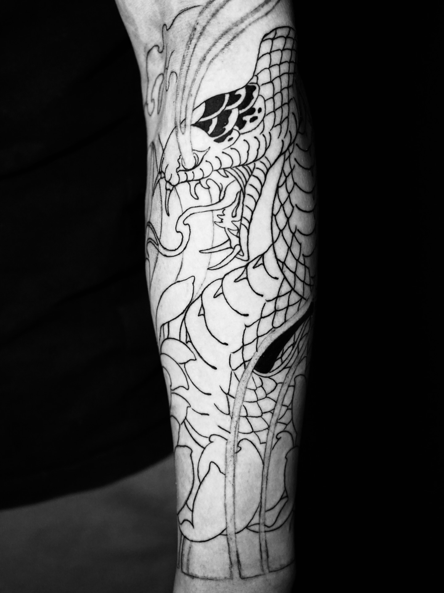 Dragon black and grey tattoo on the forearm by Anh Nguyen