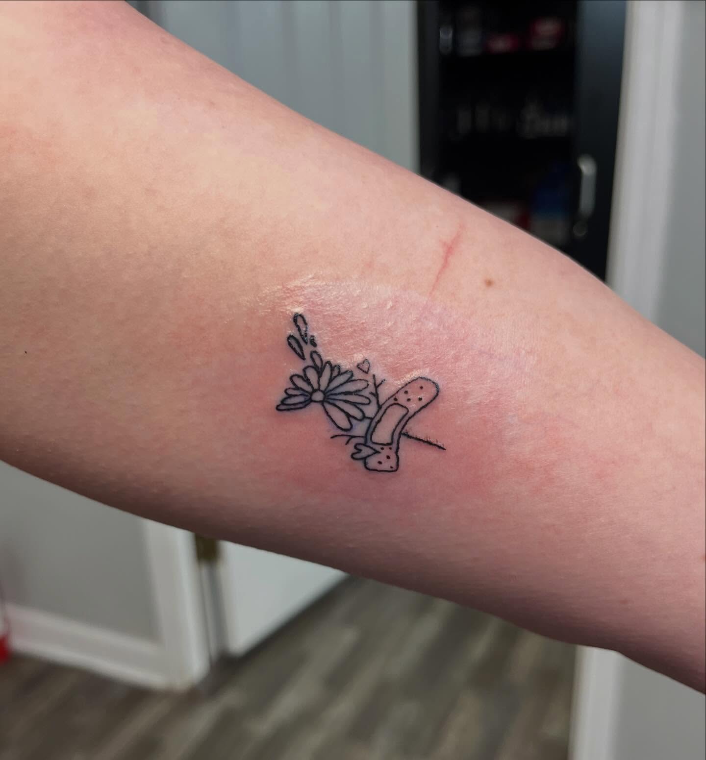 Flower and bandage black and grey tattoo on the forearm by XoXandrea.Ink, Kansas City, Missouri