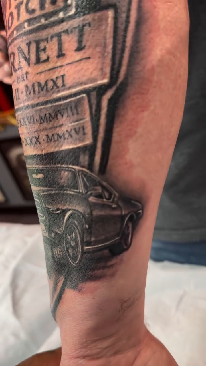 Memorial tattoo with car and dates realism tattoo by Alejandro Zaragoza