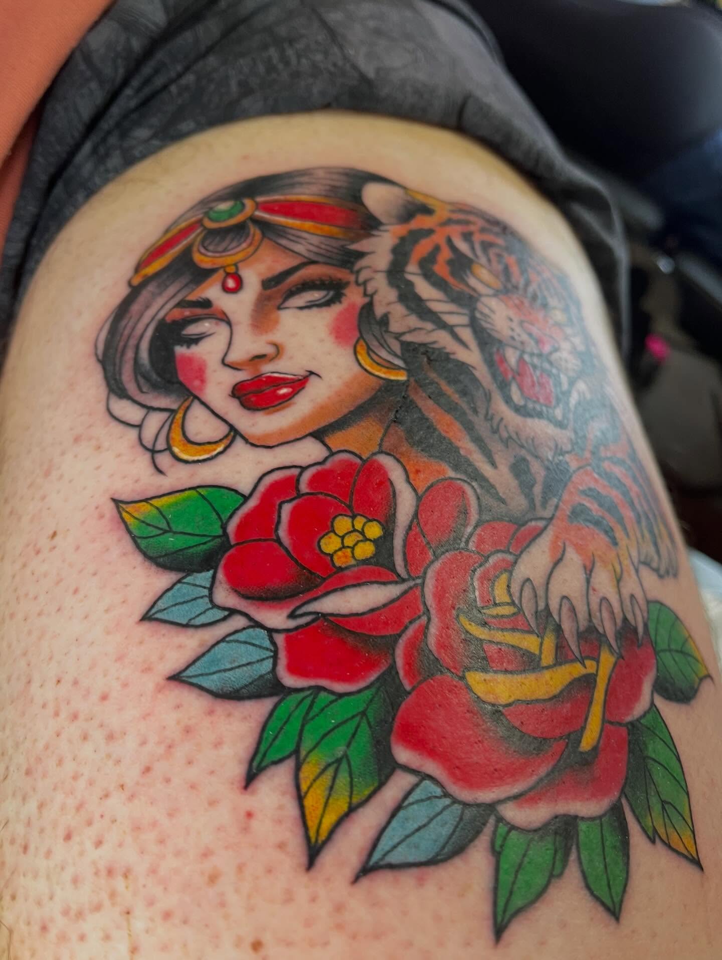 Woman with tiger and flowers American traditional tattoo on the thigh by Josh Brownell