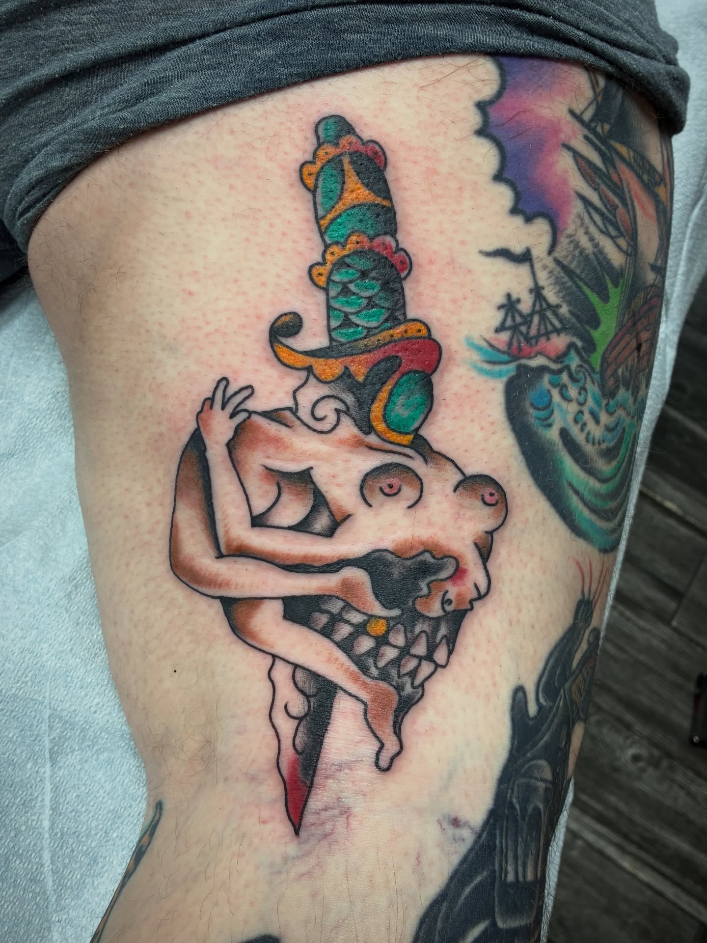 Man with knife through head American traditional tattoo on the thigh by Kennedy Cole