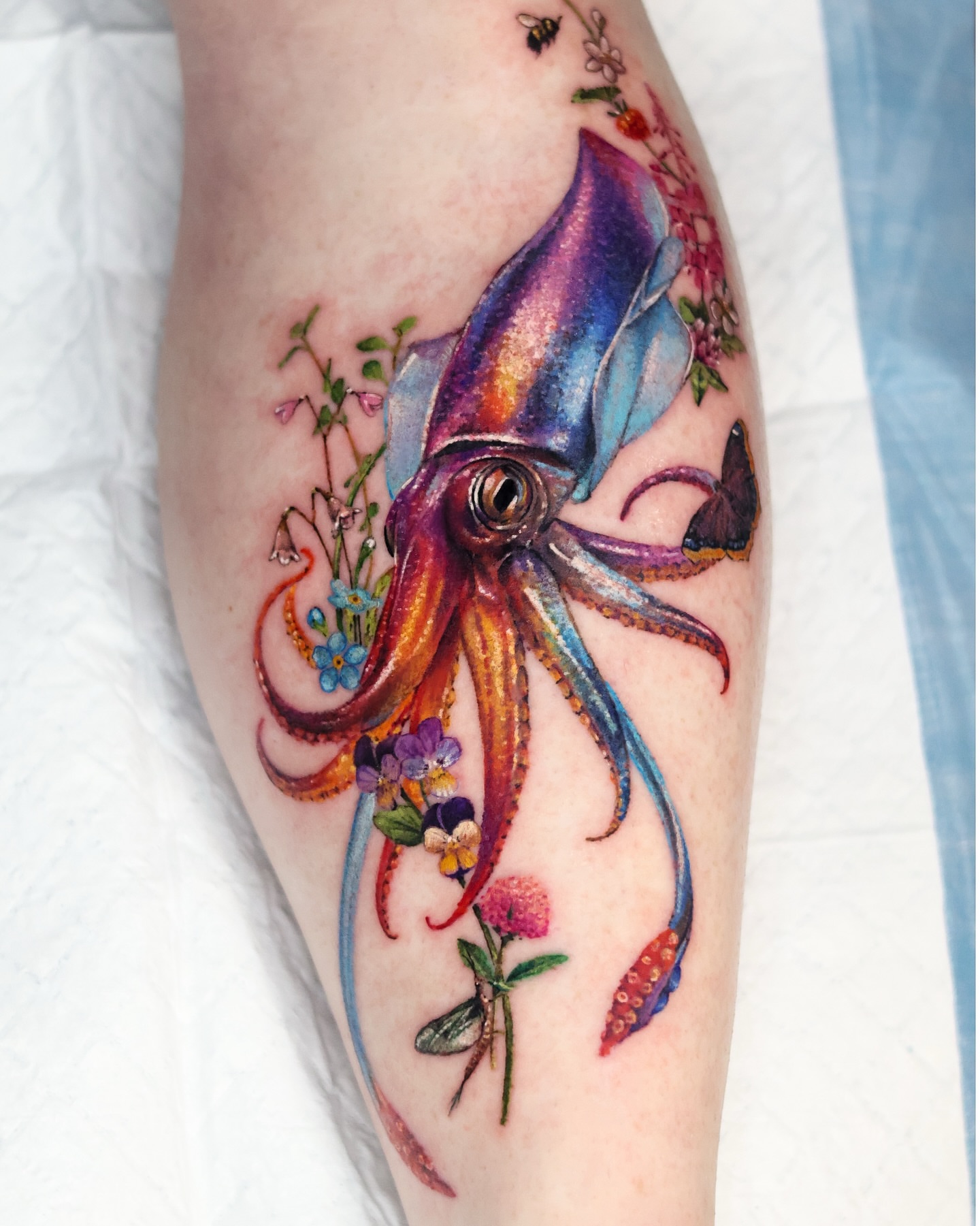 Squid and flowers watercolor tattoo on the forearm by 𝒀𝒖𝒏𝒎𝒊 𝑷𝒂𝒓𝒌