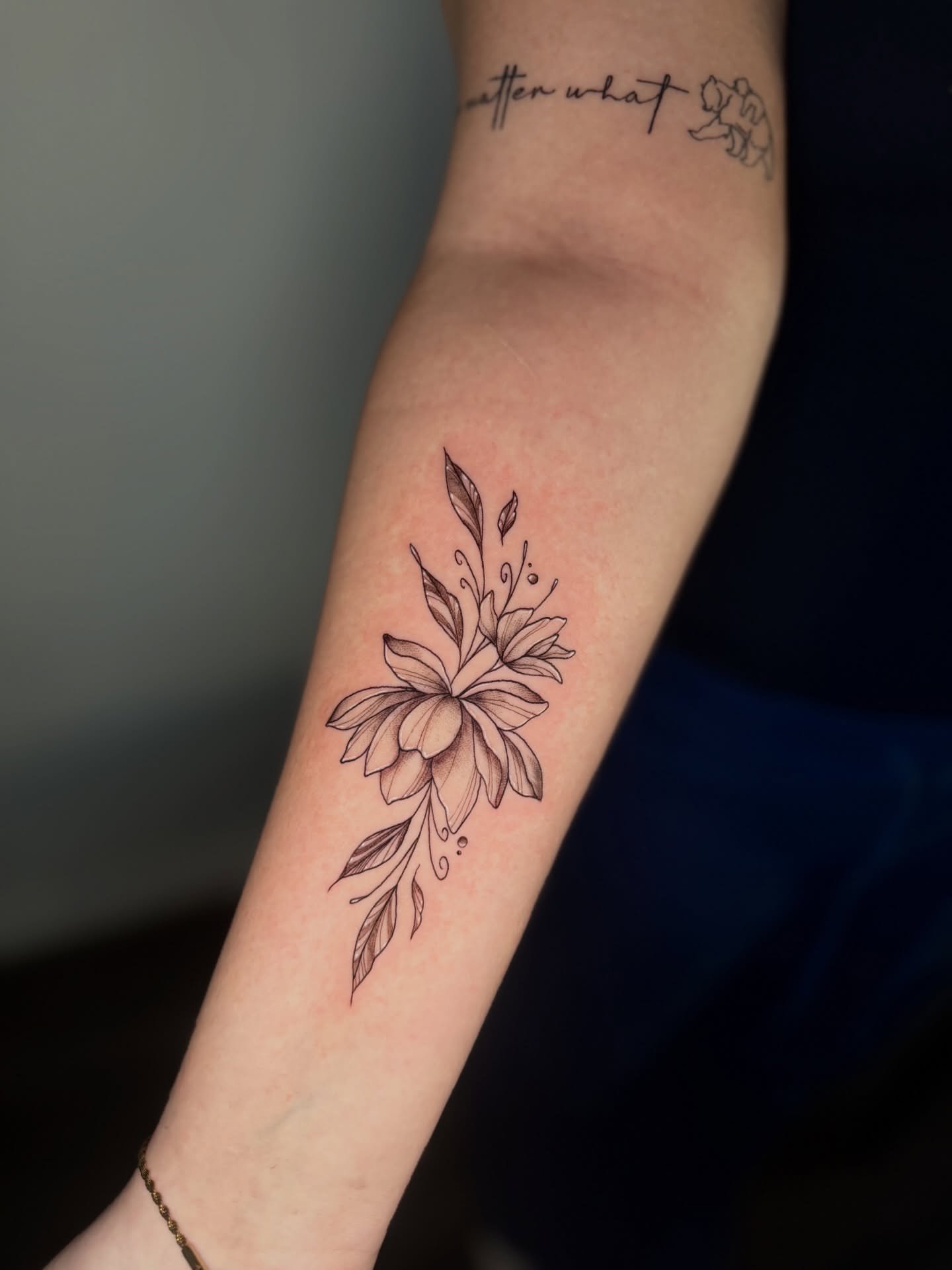 Floral arrangement black and grey tattoo on the forearm by Mandy Kaur