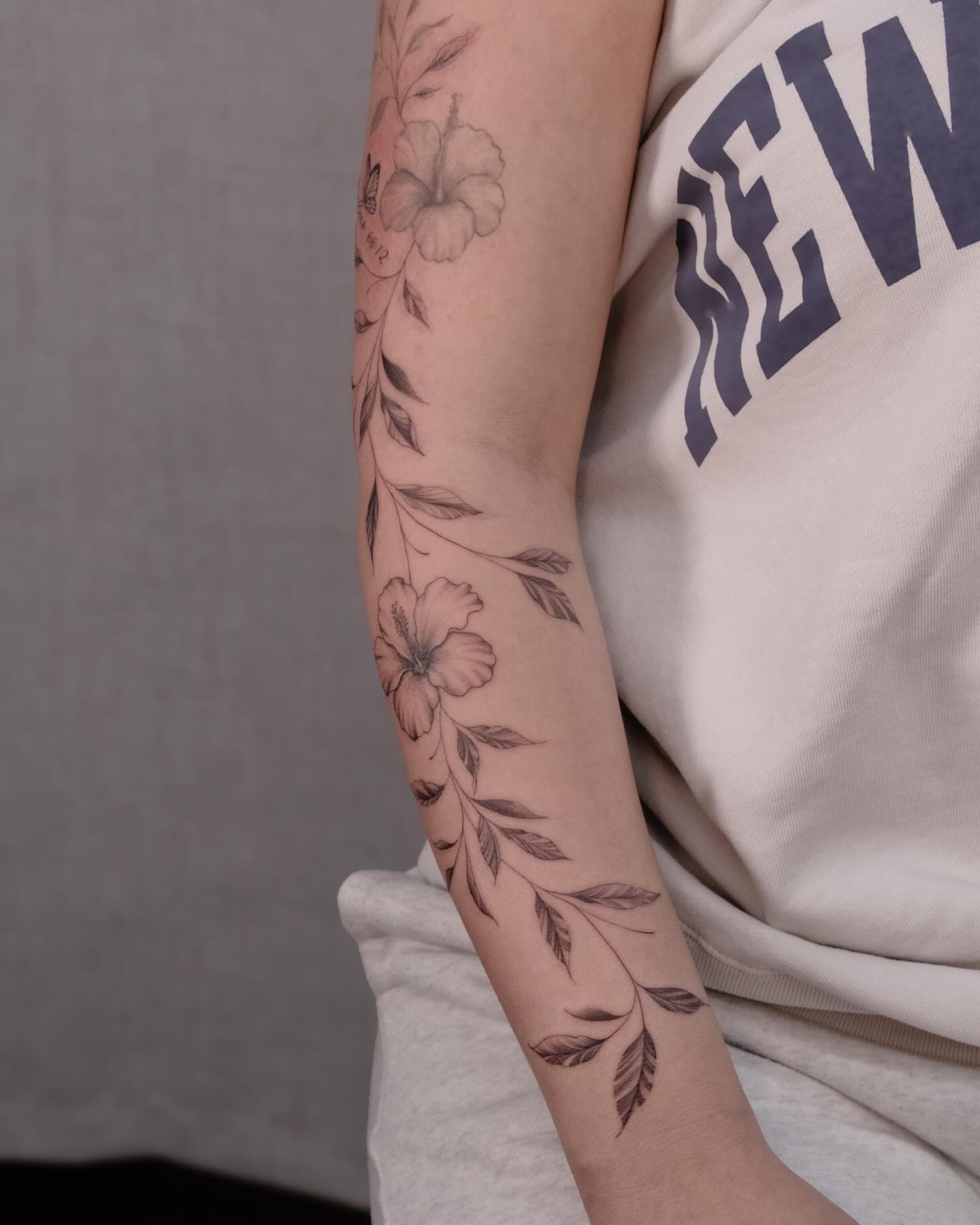 Floral design black and grey tattoo on the forearm by Koko