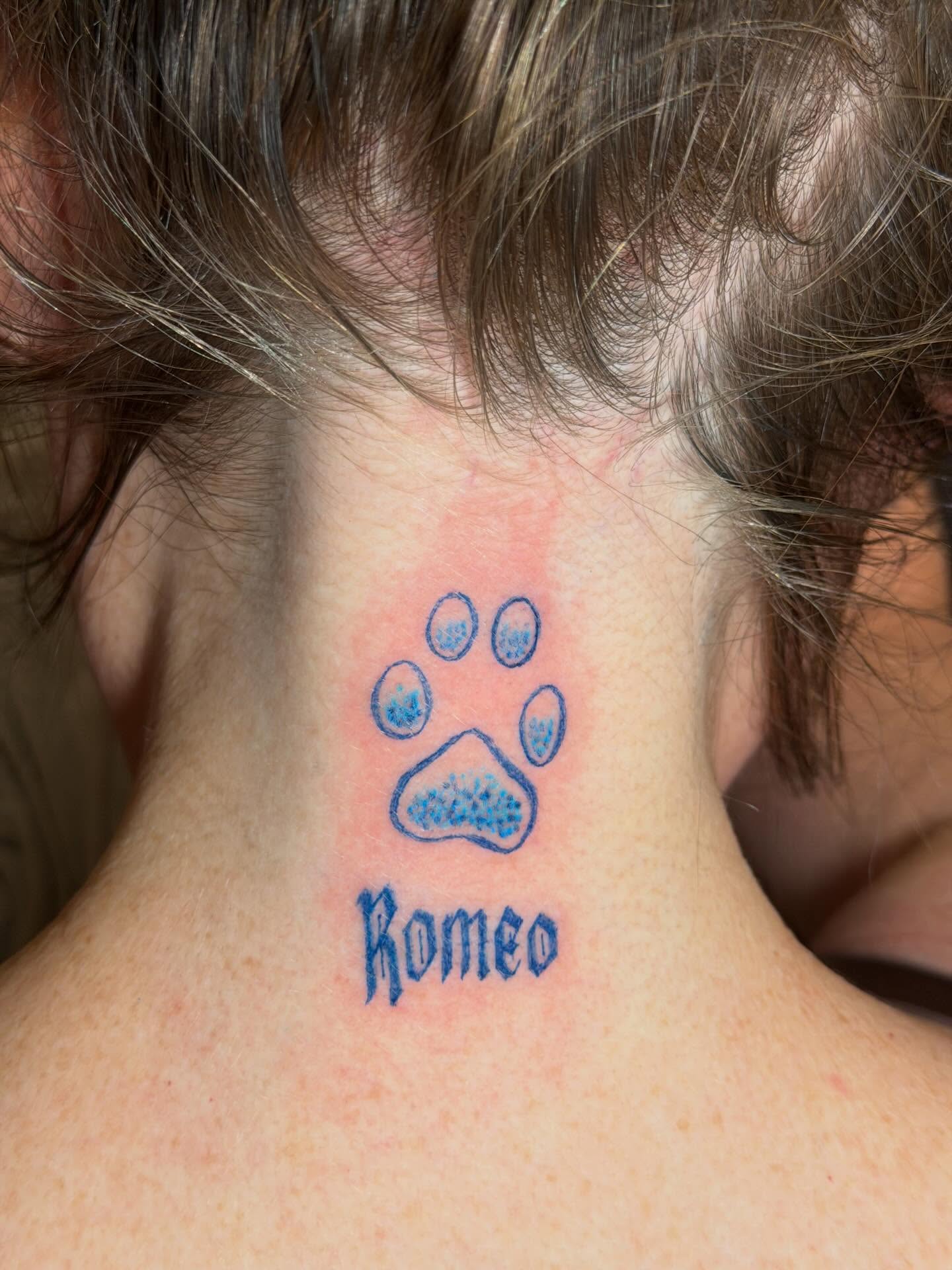 Dog paw print dotwork tattoo on the neck by C.J.K. Roy