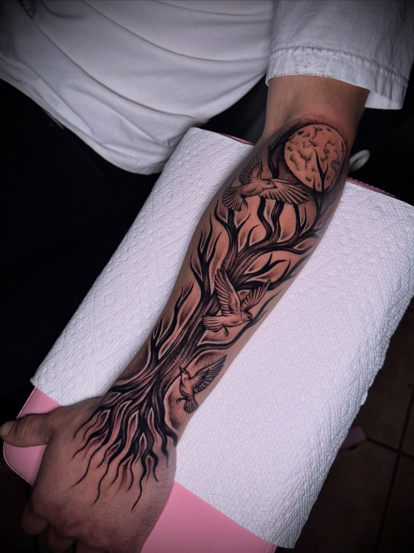 Tree with birds black and grey tattoo on the forearm by Tattoo Artist based in Dallas Tx
