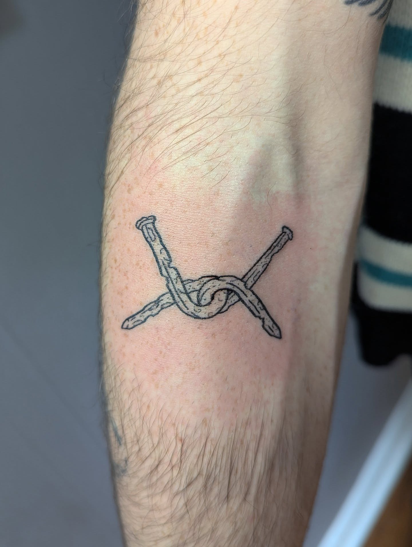 Nail and knot black and grey tattoo on the forearm by Patricio