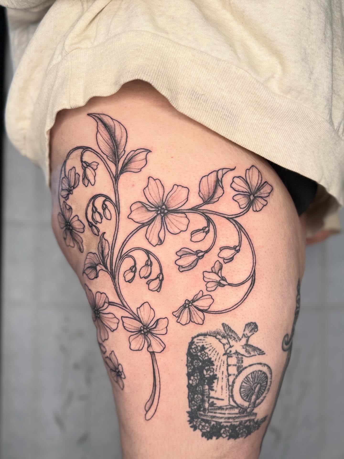 Floral vine black and grey tattoo on the thigh by Noelle Adrienne Tattoos