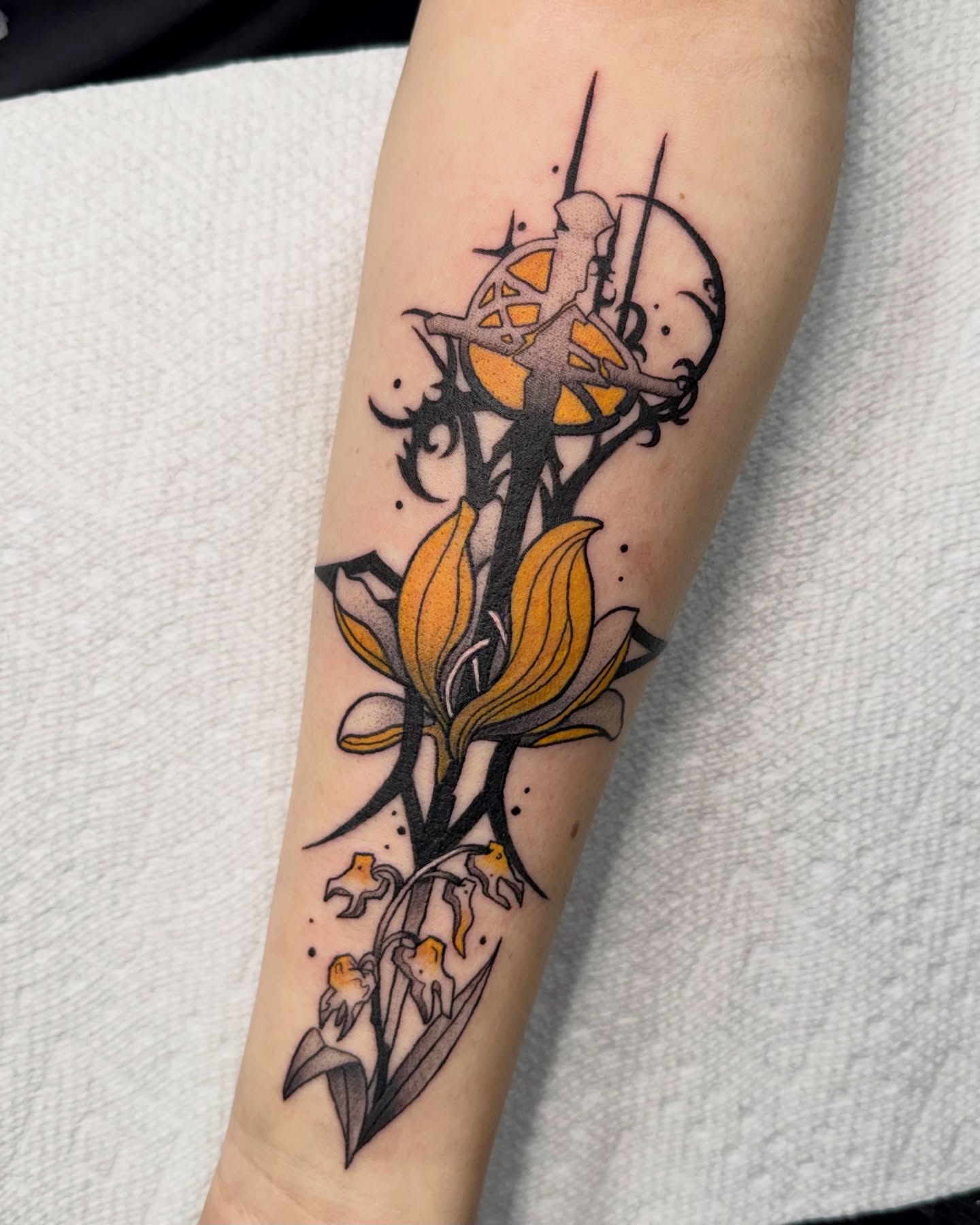 Lily and fairy neo-traditional tattoo on the forearm by Eden Allen