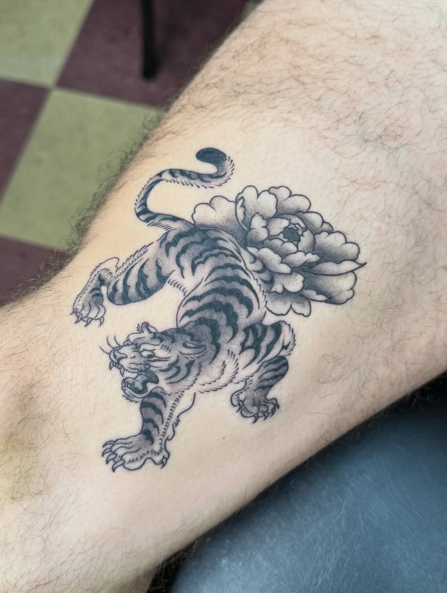 Tiger and peony black and grey tattoo on the forearm by Cora Phelps