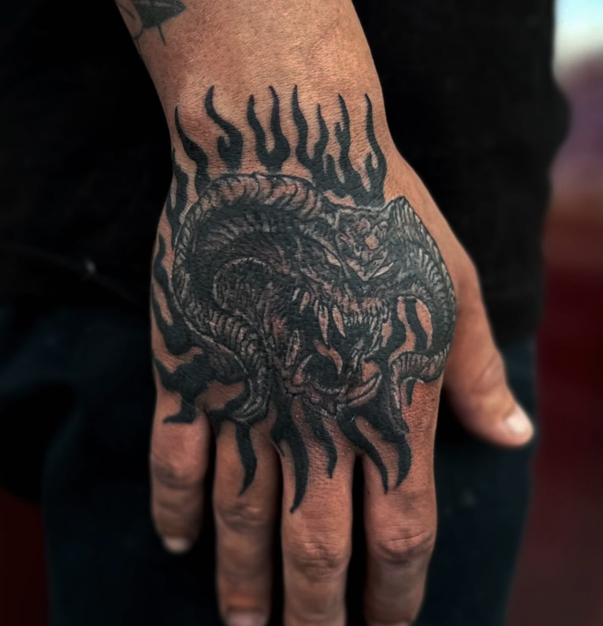Dragon black and grey tattoo on the hand by Brooke