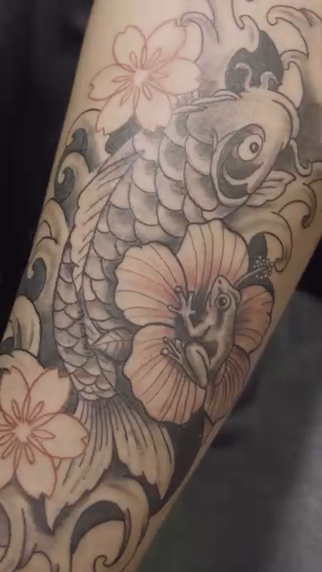 Koi fish and flowers Japanese tattoo on the upper arm by Alexander Haber