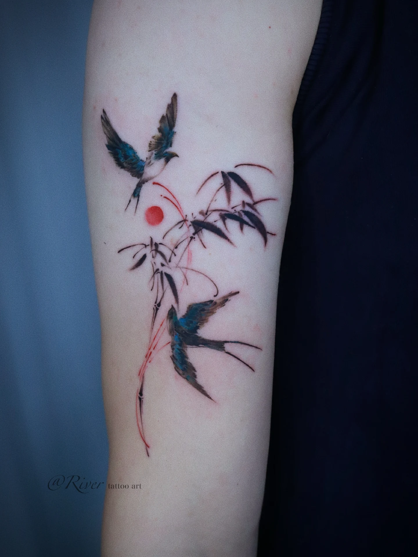 Birds and bamboo watercolor tattoo on the forearm by River