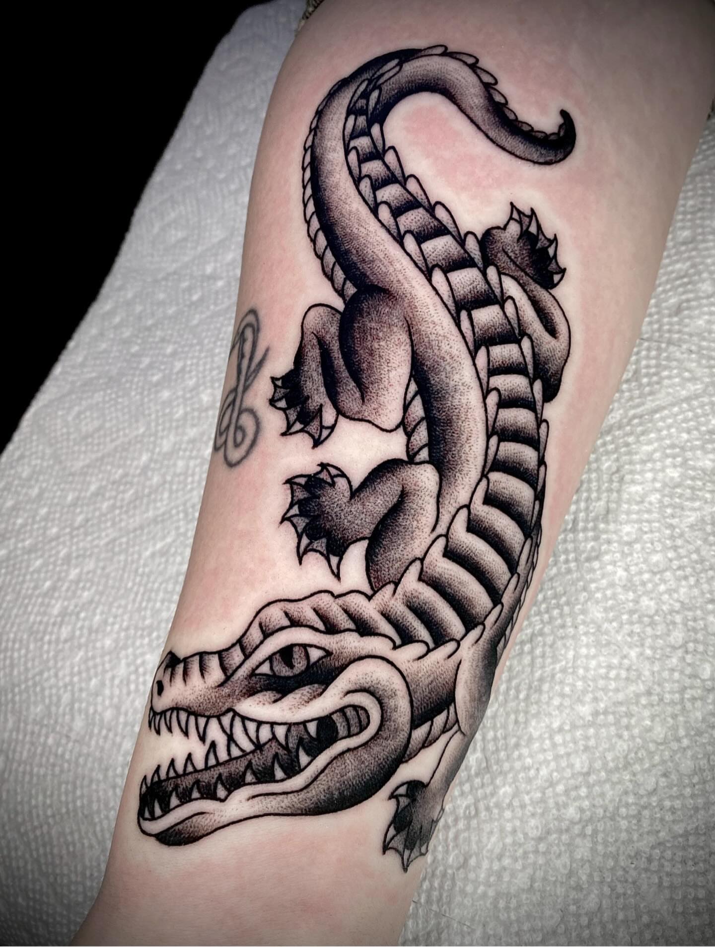 Alligator black and grey tattoo on the forearm by Zach Knisley (Wiz)
