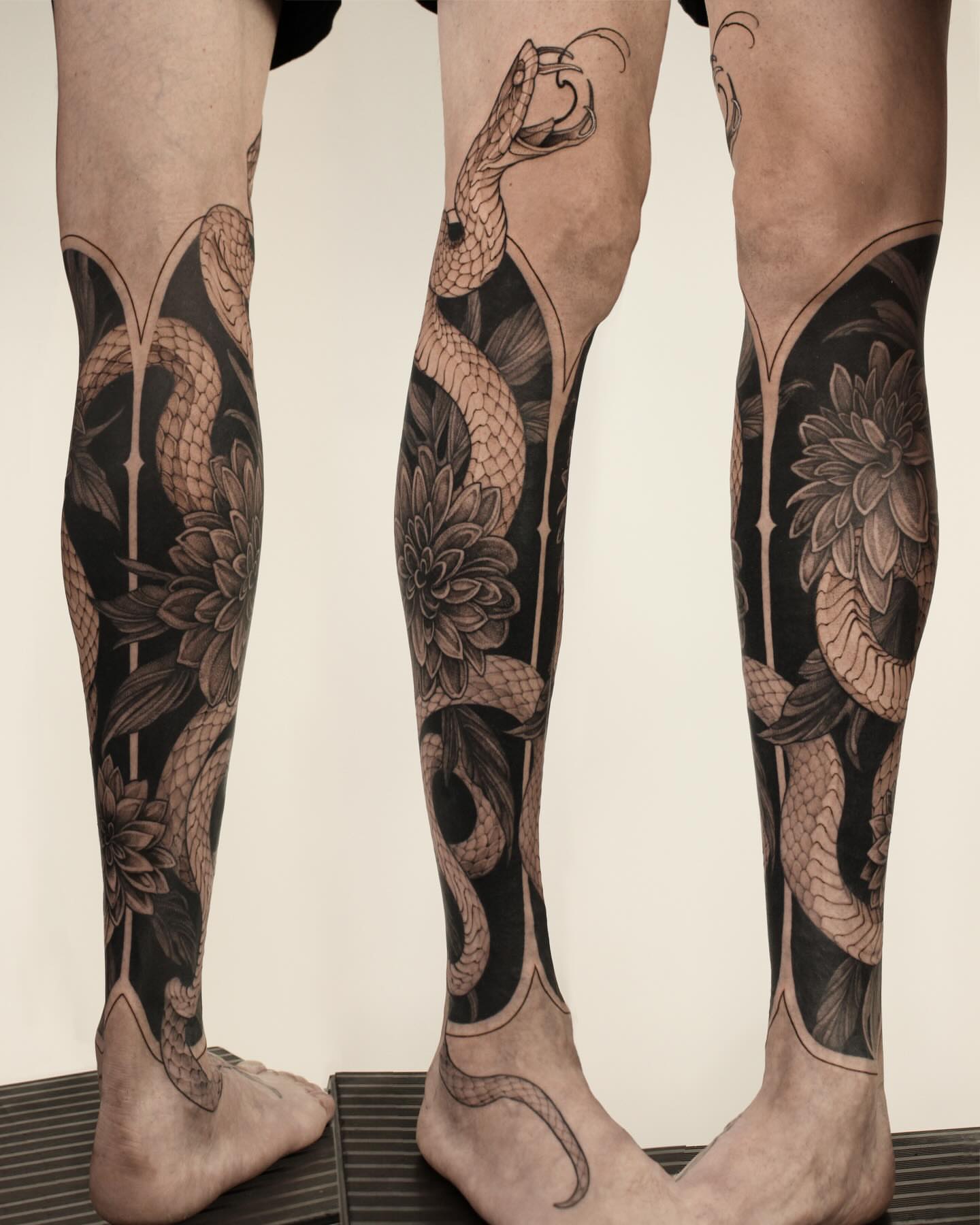 Snake and flowers realism tattoo on the leg by Heather Apgar
