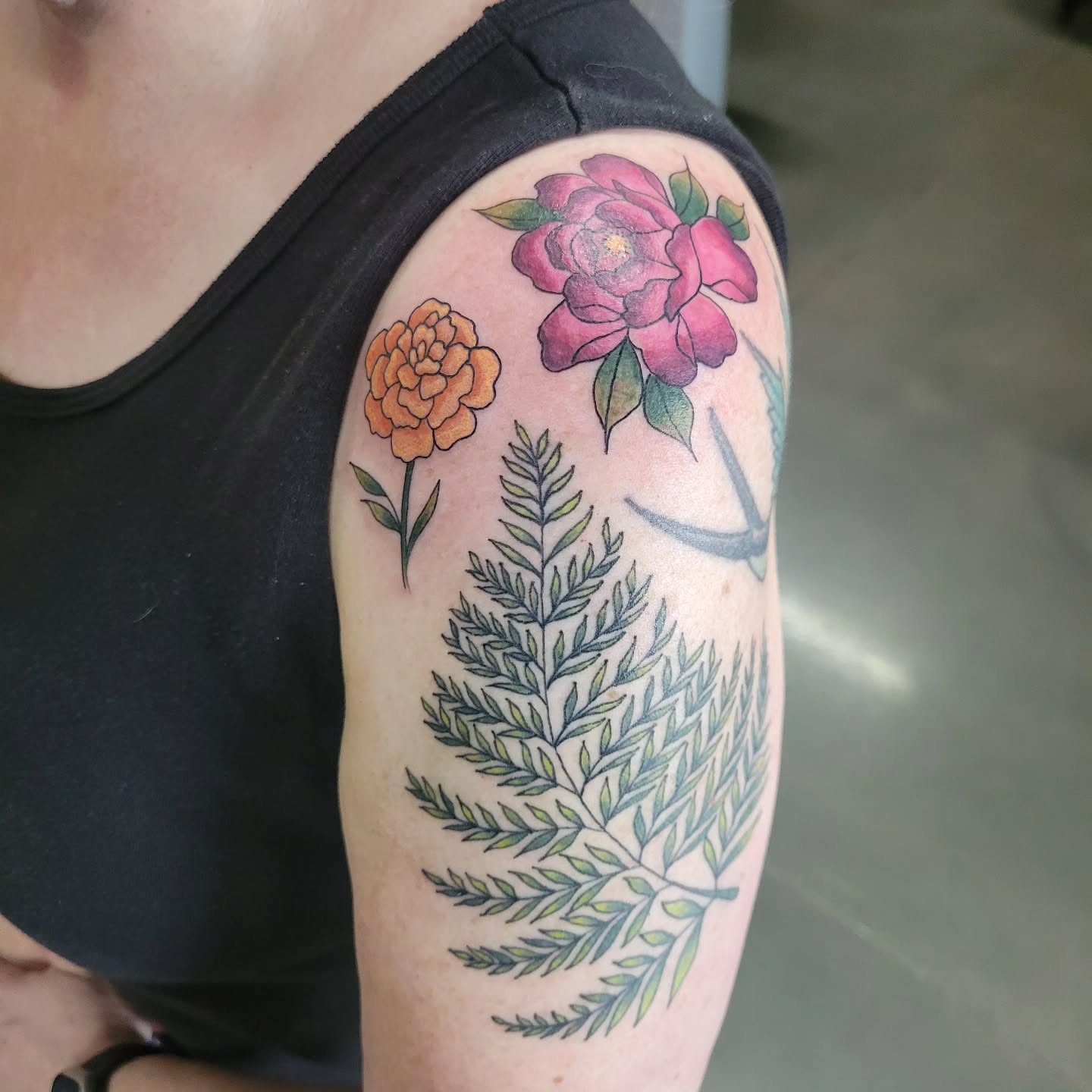 Floral arrangement realism tattoo on the upper arm by Aspen C