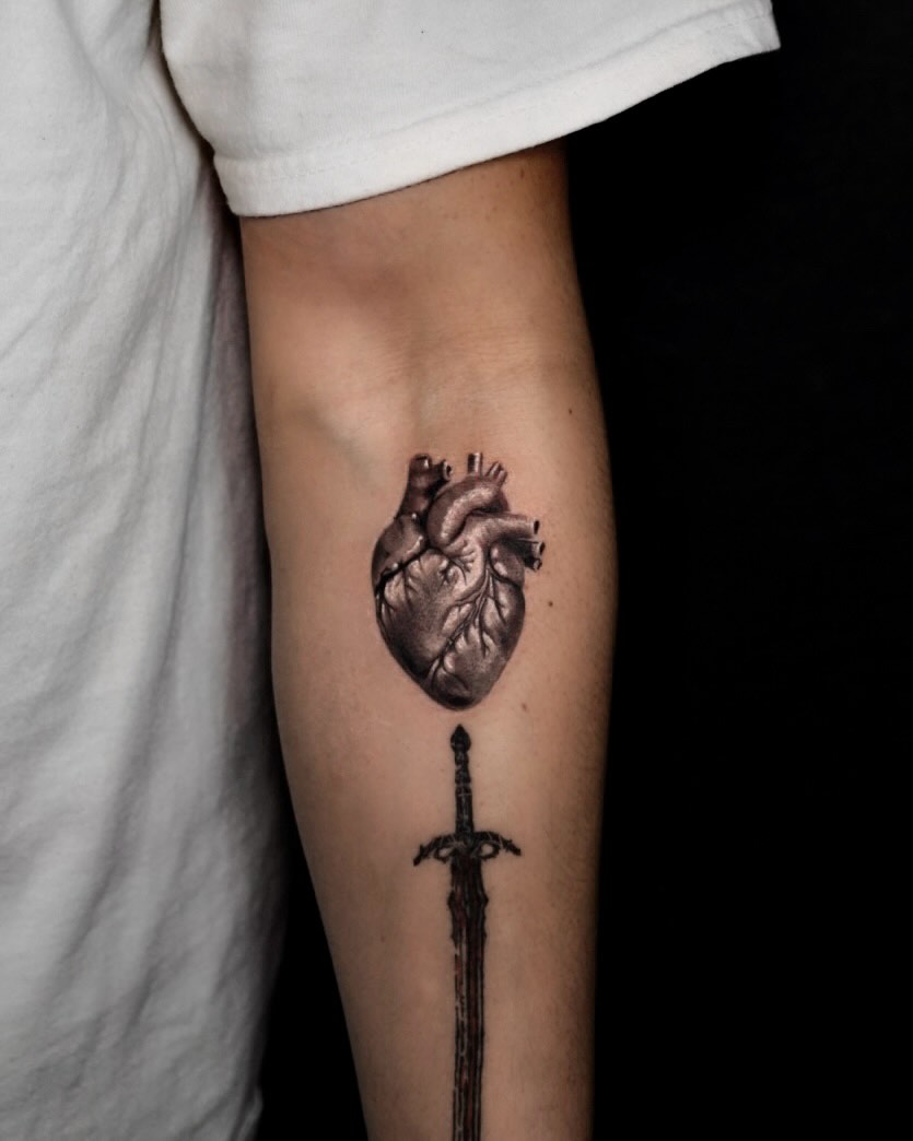 Heart and sword realism tattoo on the forearm by Tattoo Artist