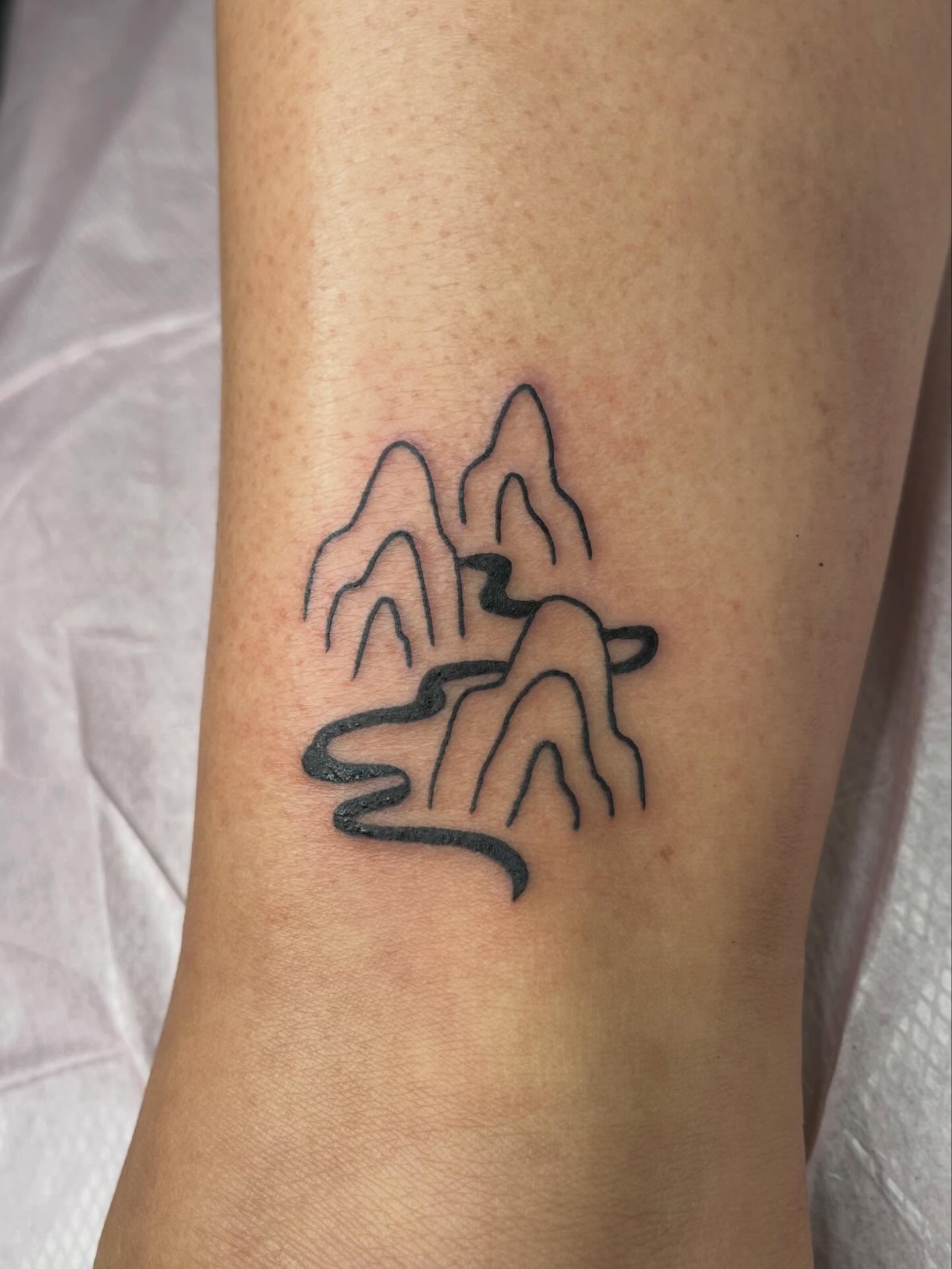 Mountains minimalist tattoo on the forearm by ashley π²
