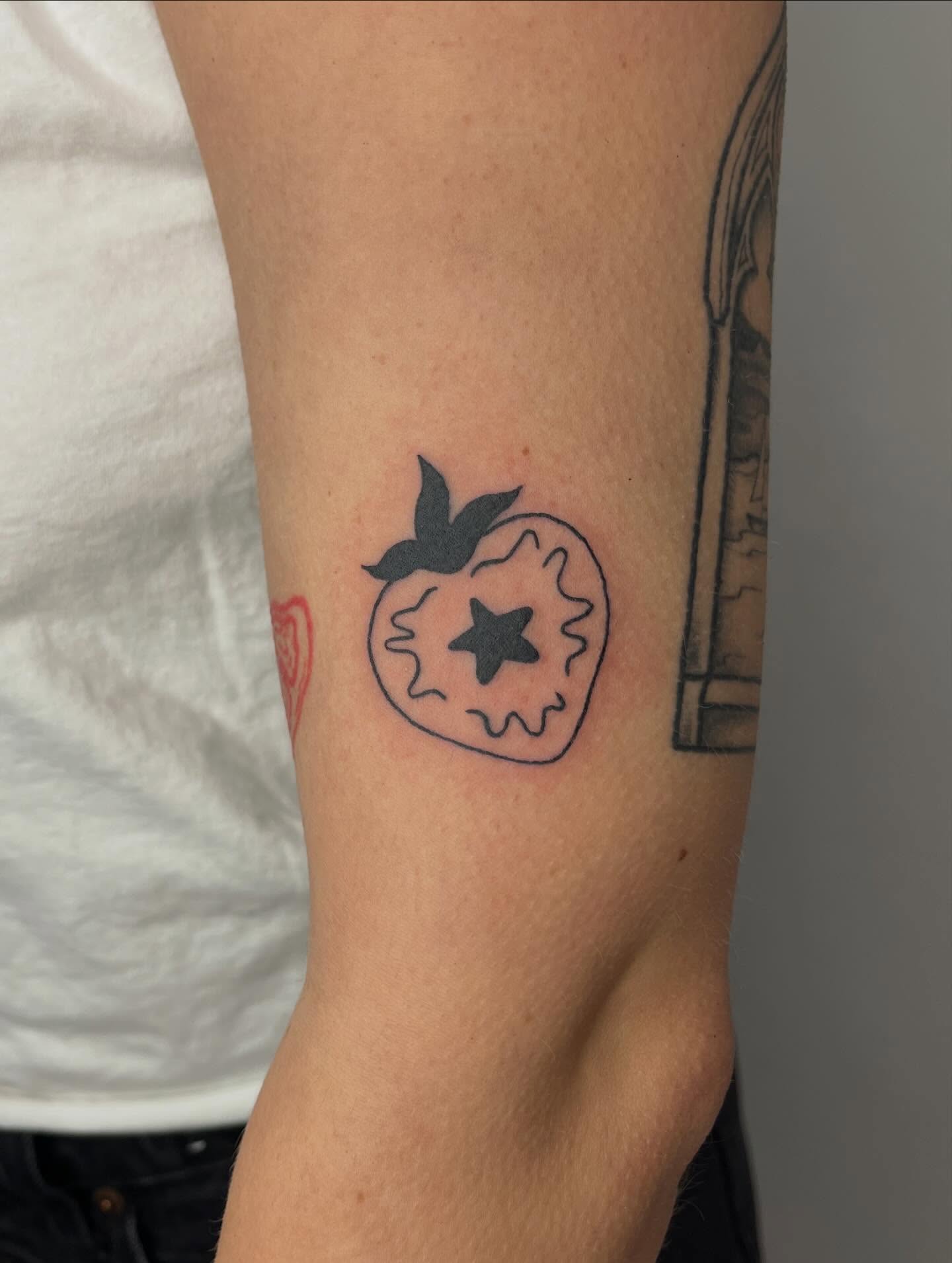 Strawberry with star minimalist tattoo on the forearm by ashley π²