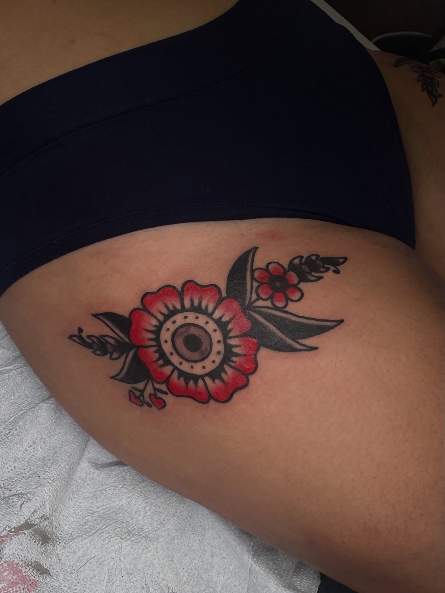 Flower American traditional tattoo on the thigh by lily gustave i tattoo