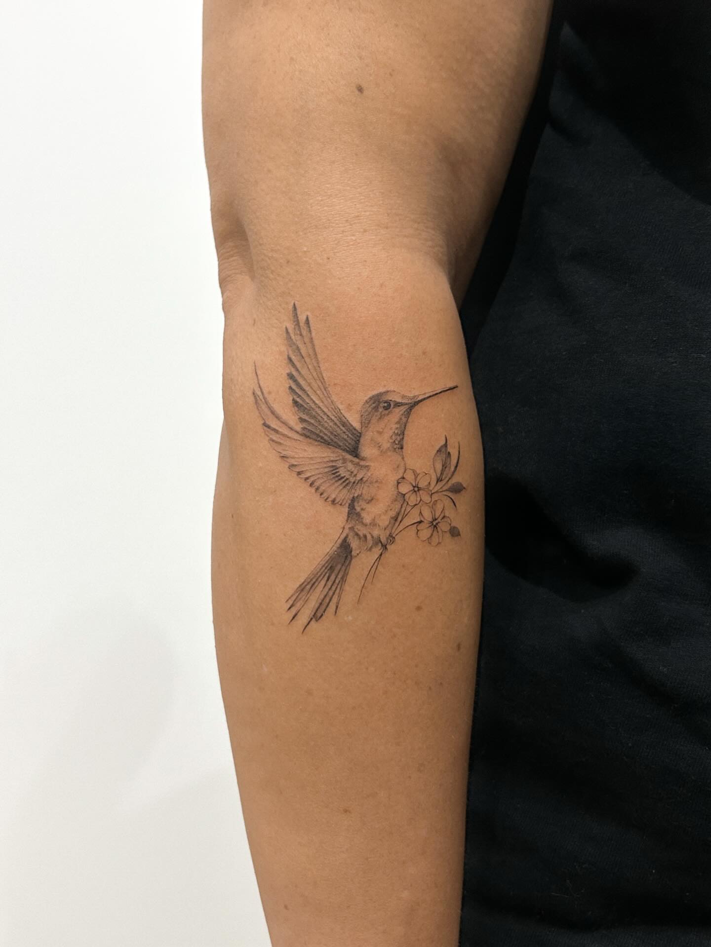 Hummingbird and flowers realism tattoo on the forearm by Chloe