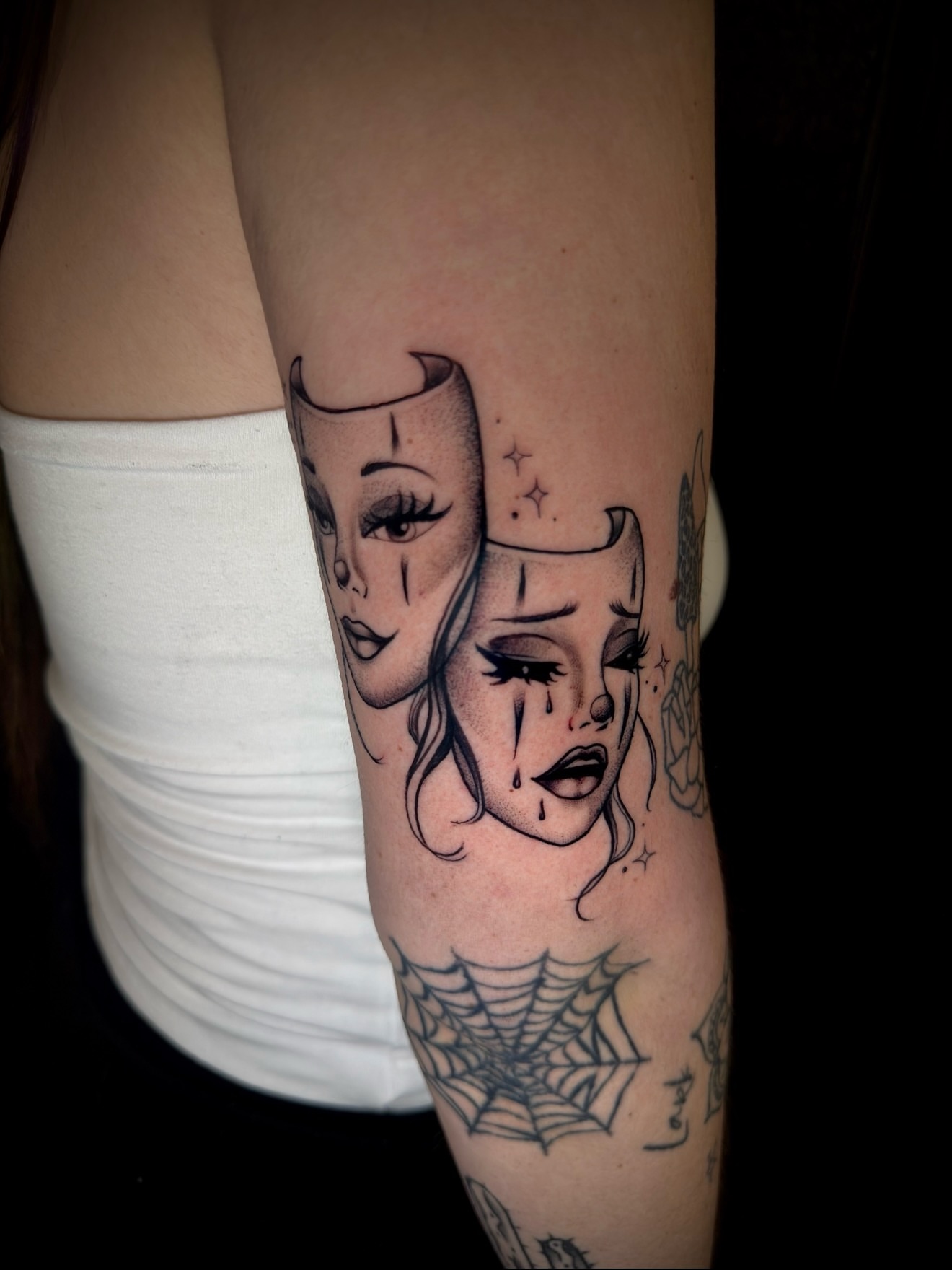 Mask and woman's face black and grey tattoo on the forearm by Thomas Martinez