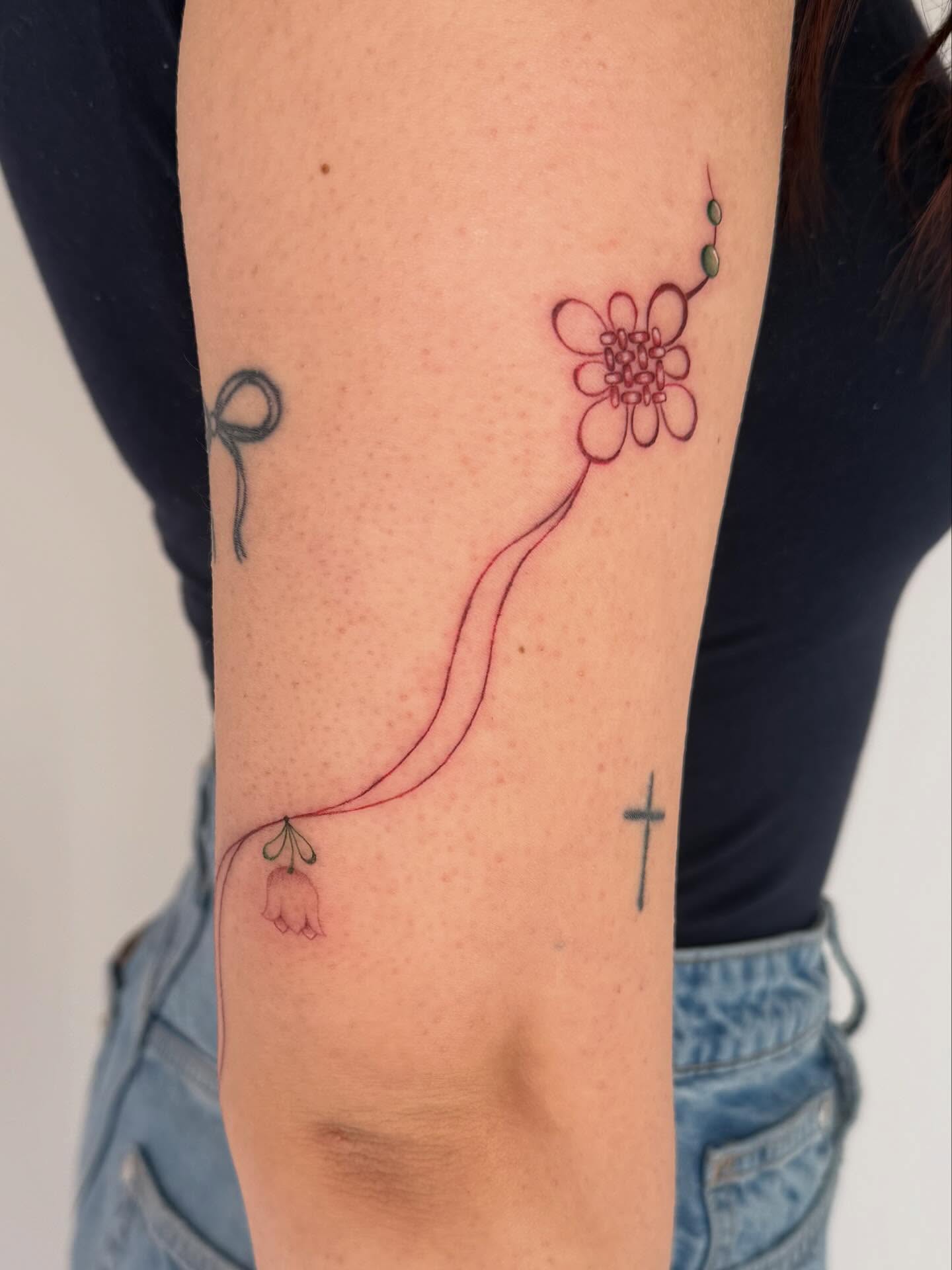 Flower and bell dotwork tattoo on the forearm by Leah Ramos