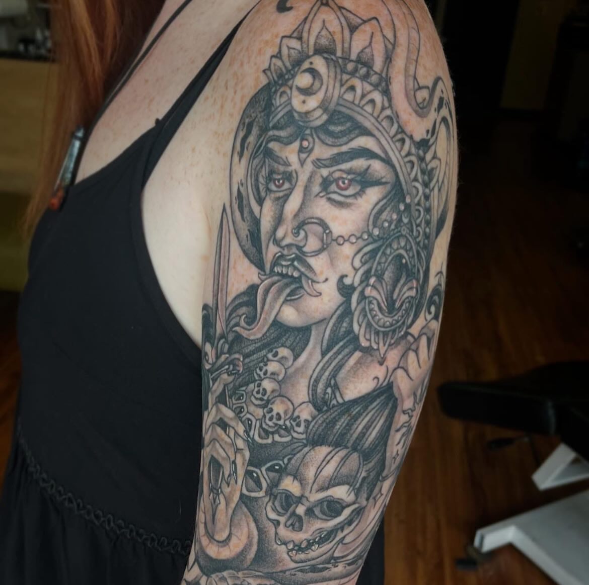 Woman with snake realism tattoo on the upper arm by Taylor Santavicca