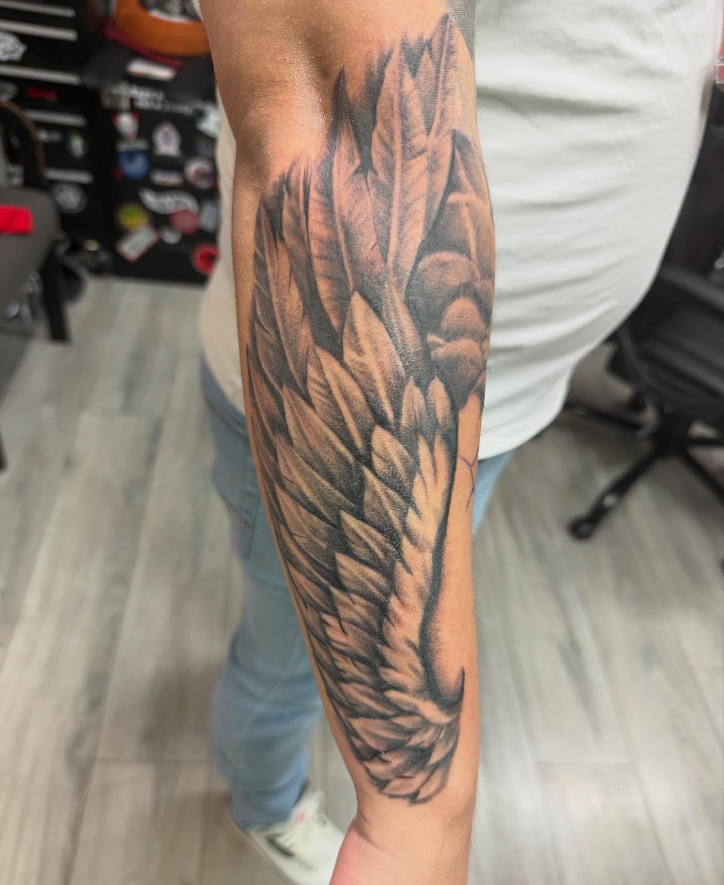 Wings black and grey tattoo on the forearm by Daniel Smith