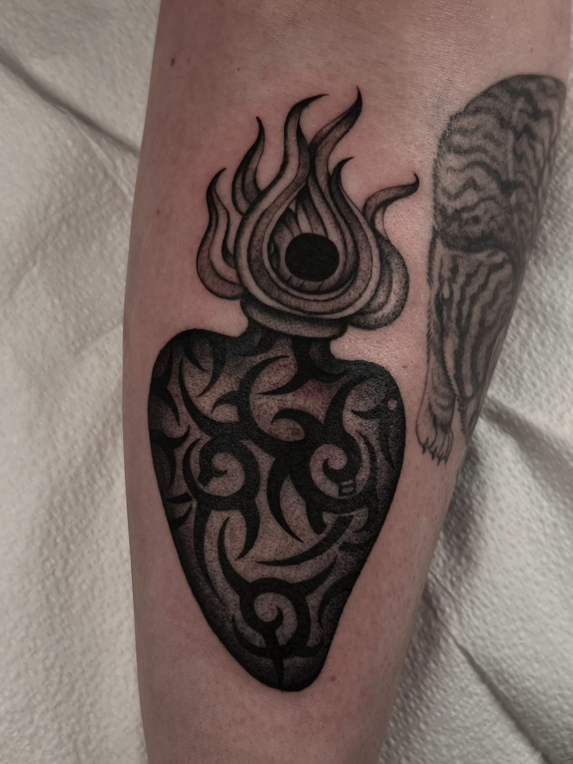 Flaming heart tribal tattoo on the forearm by Cassidy Maples