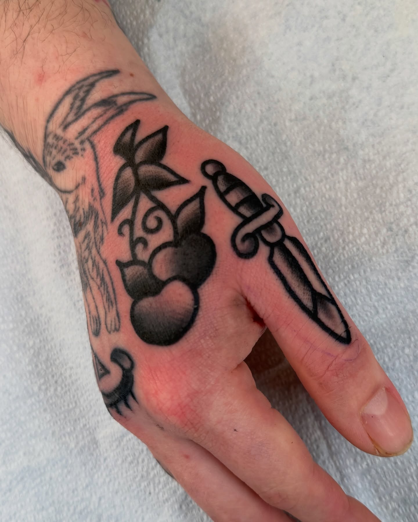 Cherry and dagger black and grey tattoo on the hand by Cullen Bleser Quinn