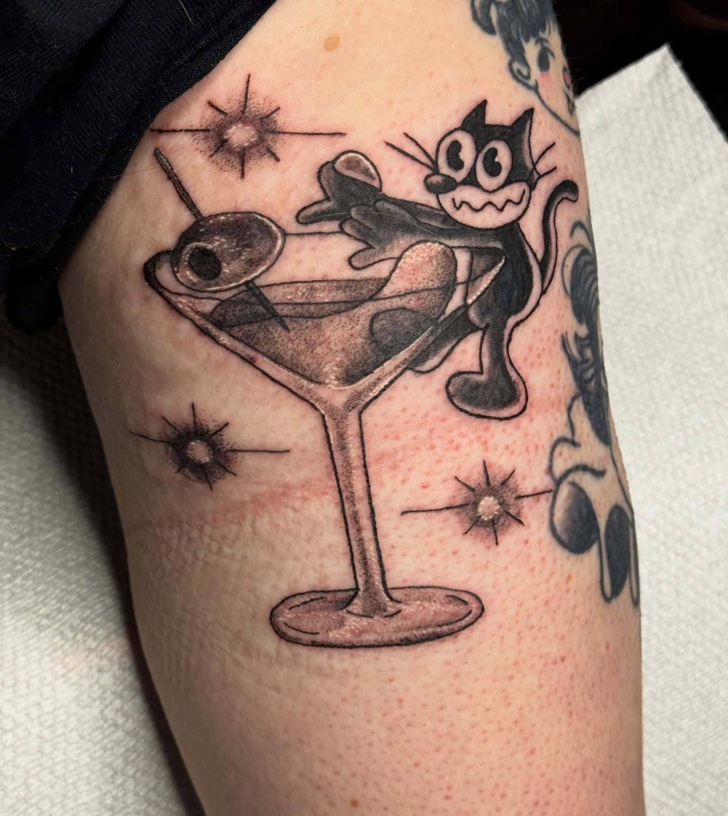 Martini glass with cat black and grey tattoo on the forearm by 🌛 𐌀𐌋𐌄𐋄𐌉𐌔 🌜