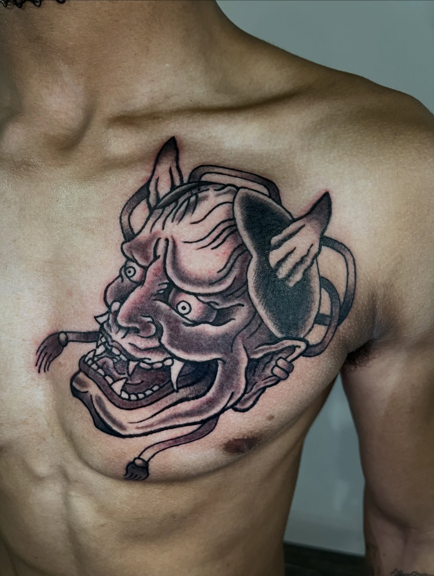 Demon mask japanese irezumi tattoo on the chest by Brian Easlon