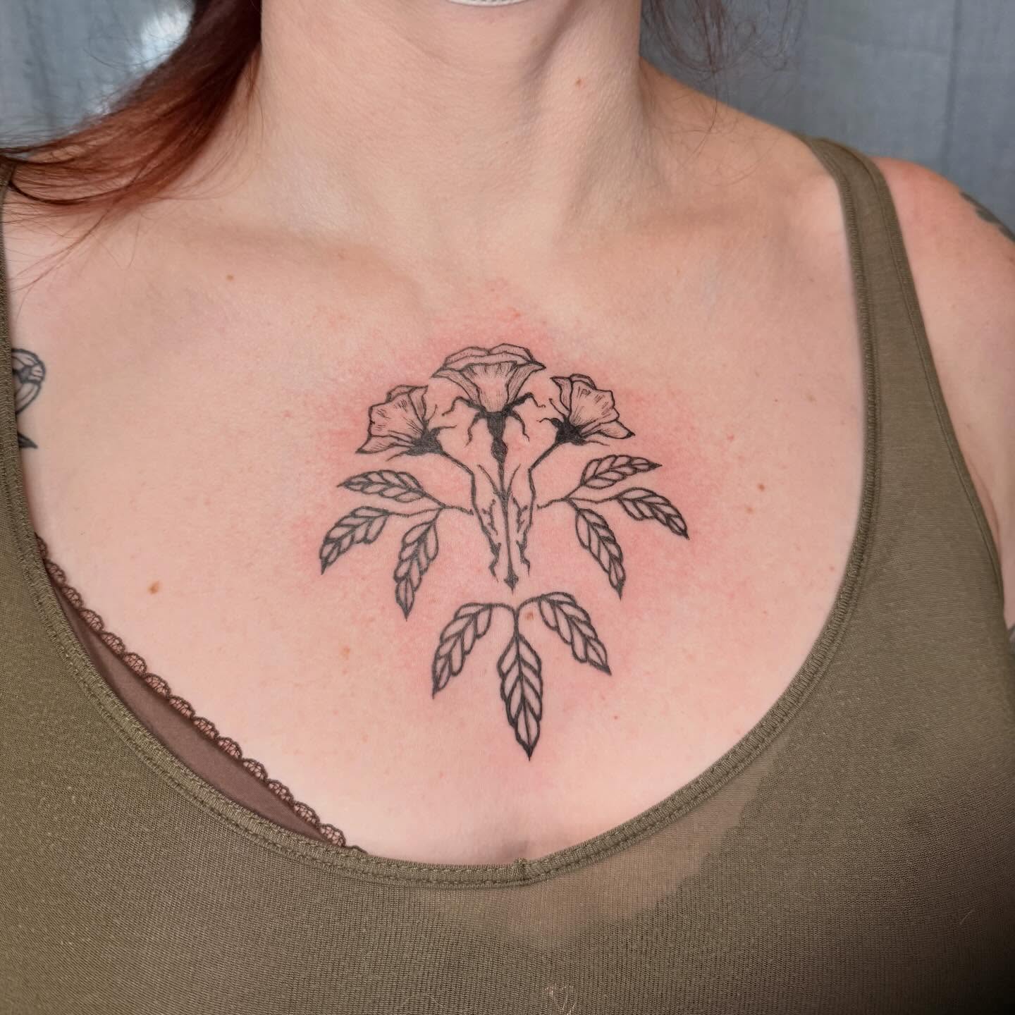 Flower arrangement black and grey tattoo on the chest by Emily Rose Lumsdaine