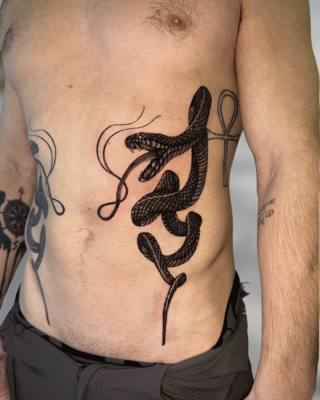 Snake realism tattoo on the torso by Ingrid Rojas