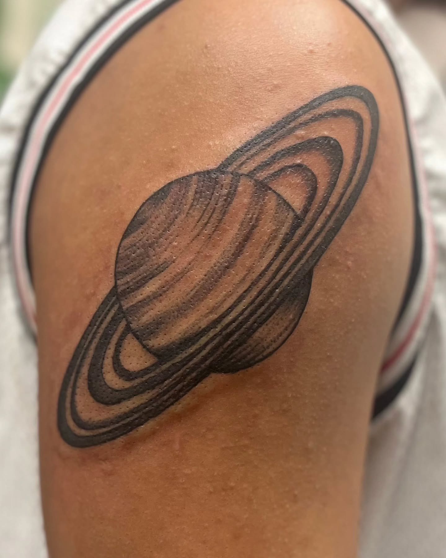 Saturn black and grey tattoo on the shoulder by Garden Glow Tattoo