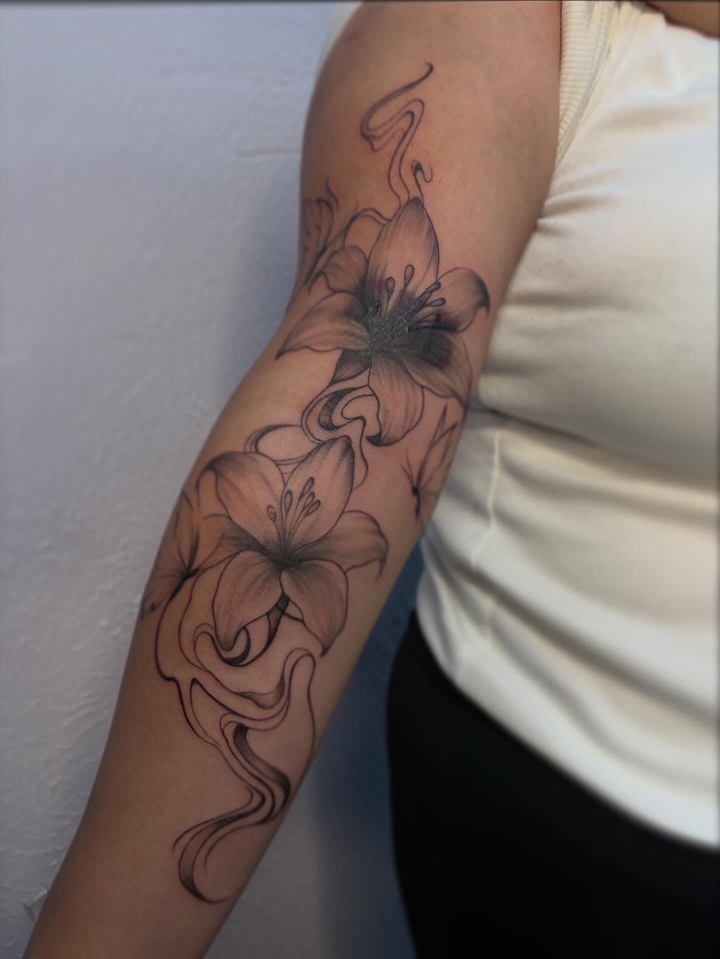 Lilies black and grey tattoo on the forearm by Jackie π€