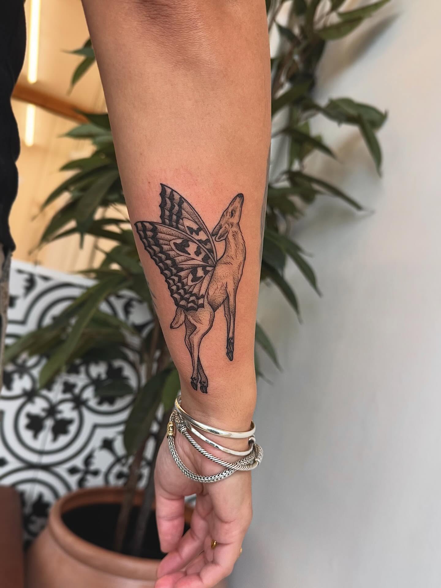 Deer with butterfly wings black and grey tattoo on the forearm by Stefany