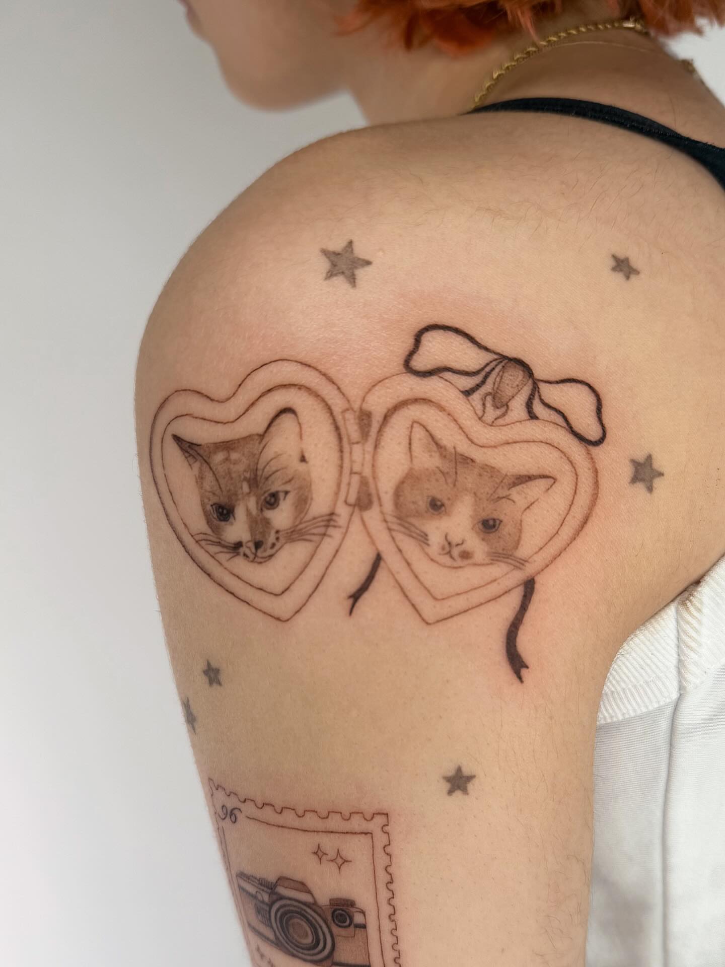 Cat faces in heart shapes realism tattoo on the shoulder by Leah Ramos