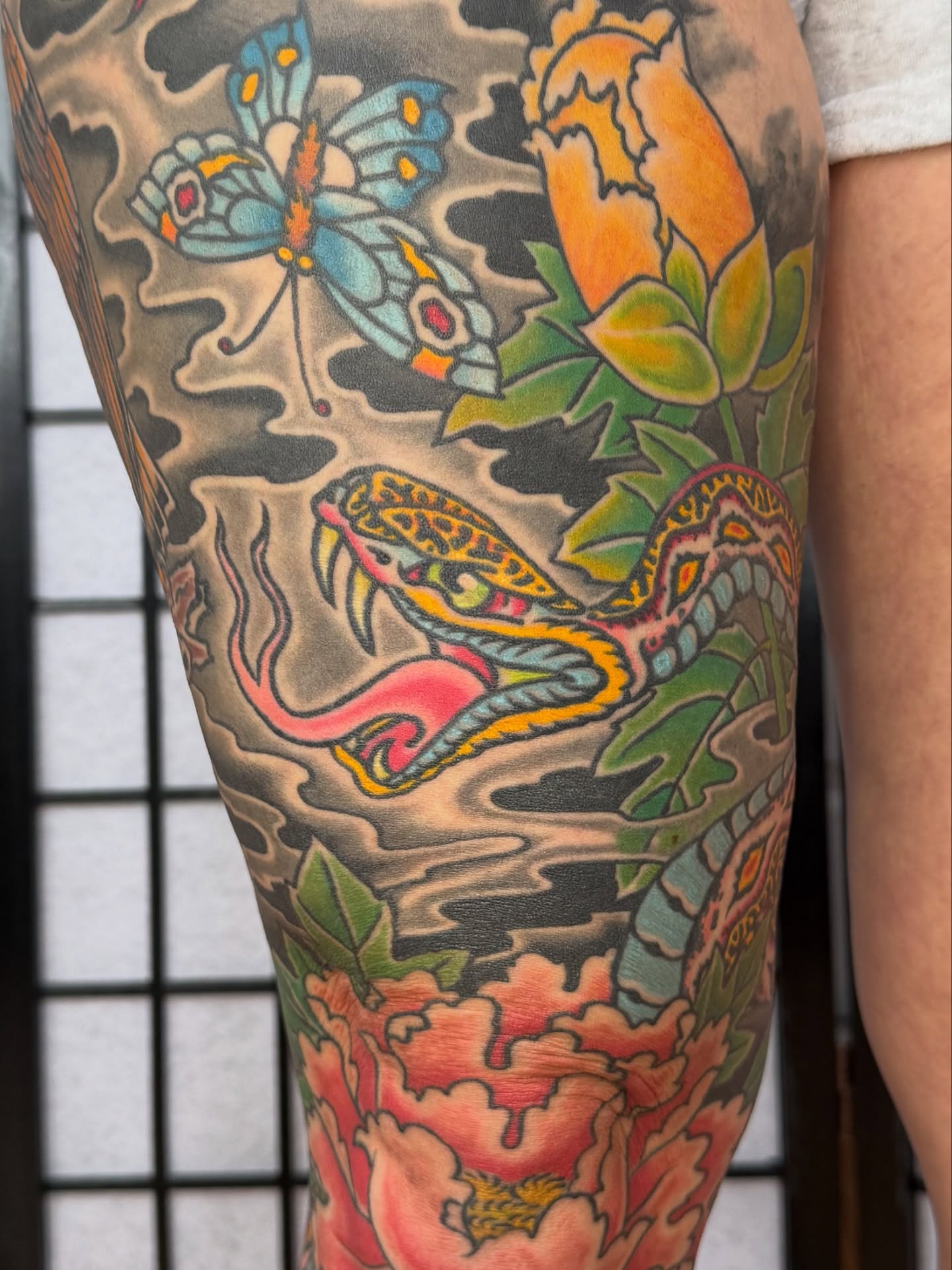 Snake and peony American traditional tattoo on the leg by Zak Colburn