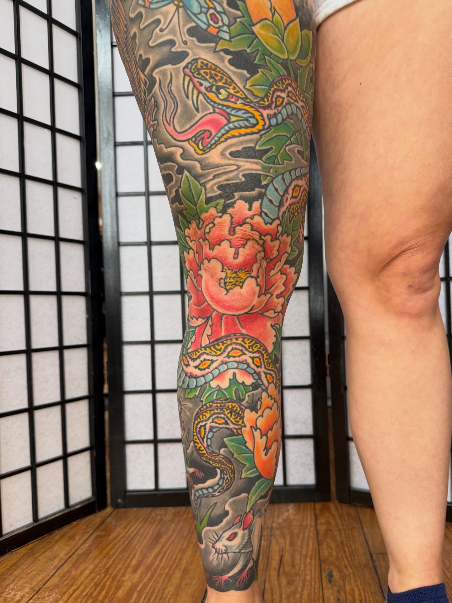 Snake and peony American traditional tattoo on the calf by Zak Colburn
