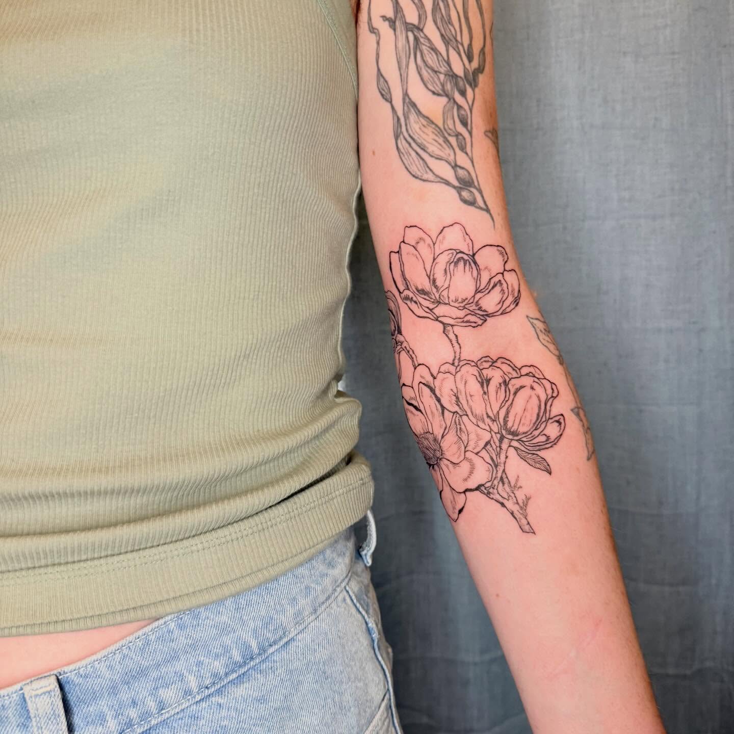 Flowers black and grey tattoo on the forearm by Emily Rose Lumsdaine