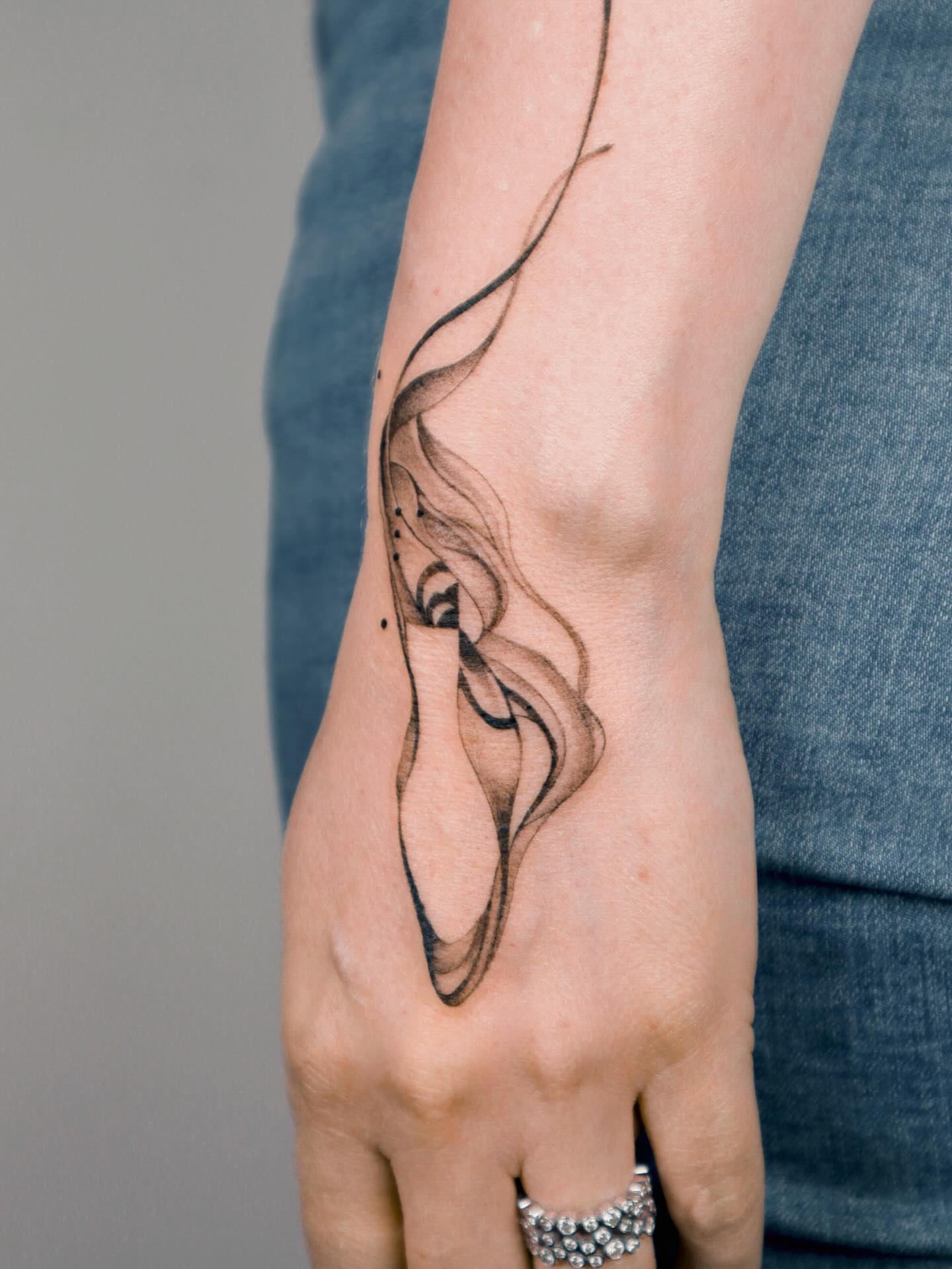 Smoke black and grey tattoo on the hand by River, New York, New York