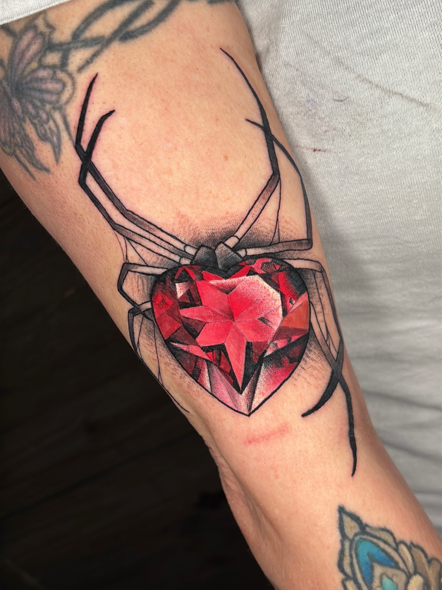 Deer with heart geometric tattoo on the forearm by Latesha Burnley