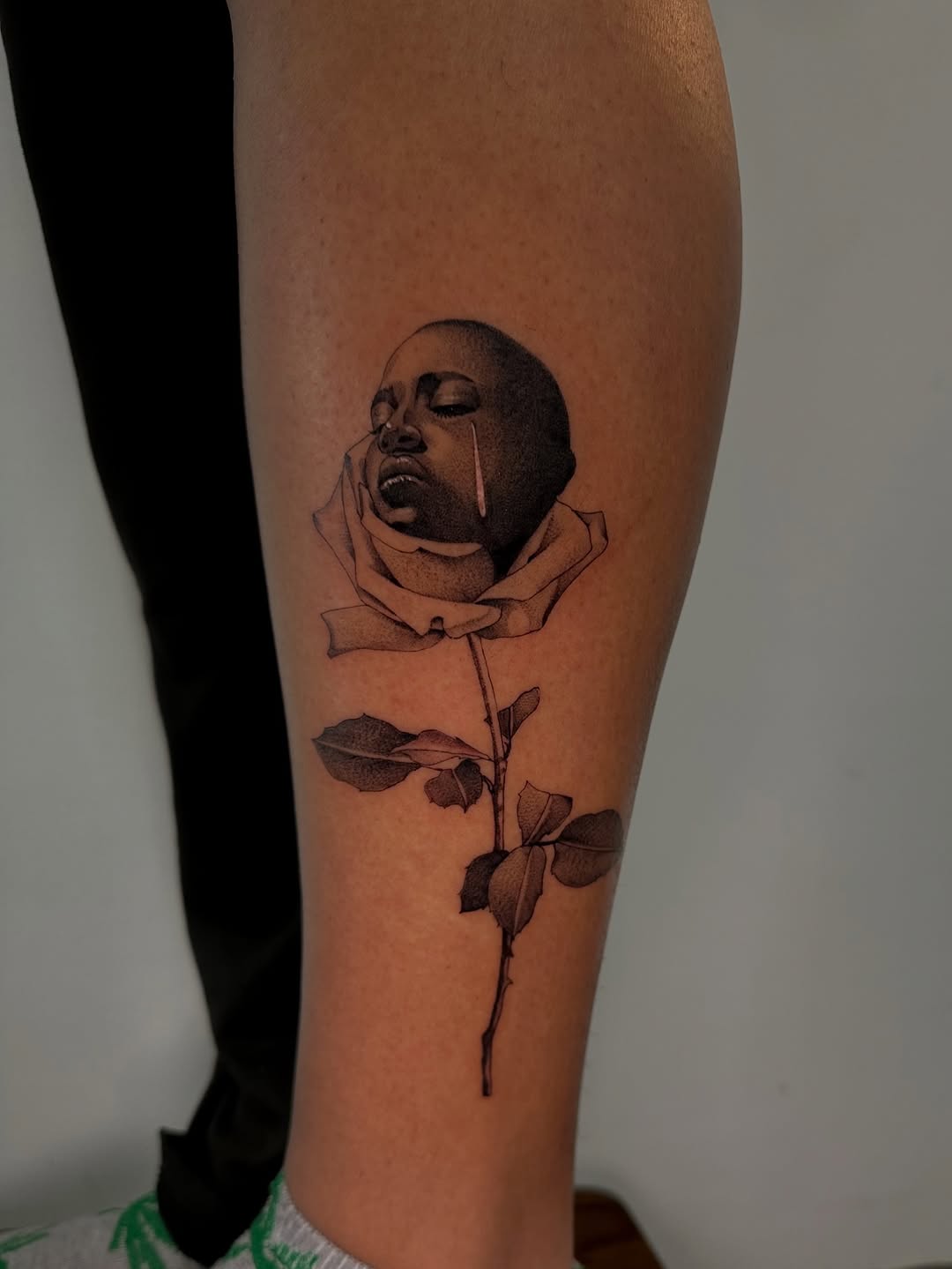 Face emerging from a rose surrealism tattoo on the forearm by 𝘋𝘪𝘢𝘯𝘯𝘢