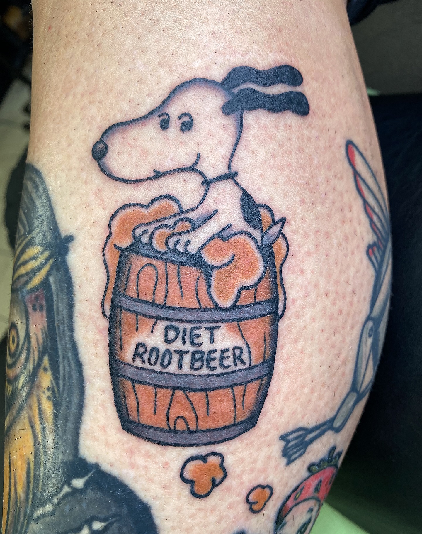 Snoopy in barrel American traditional tattoo on the thigh by Corinne Carter